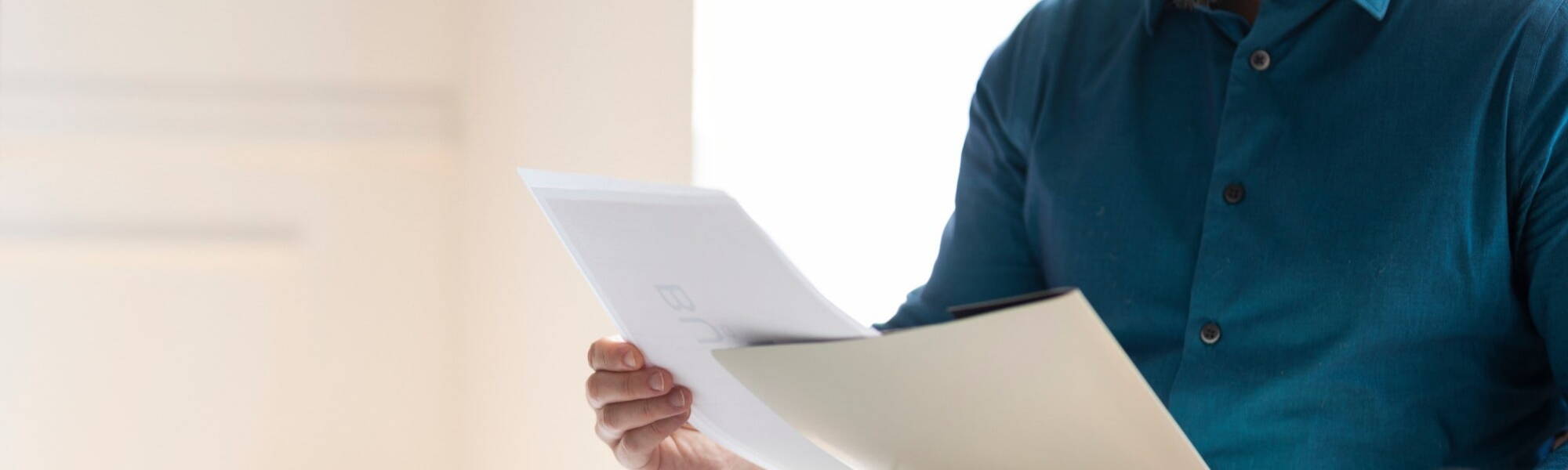 office professional wearing a blue shirt and reading a document