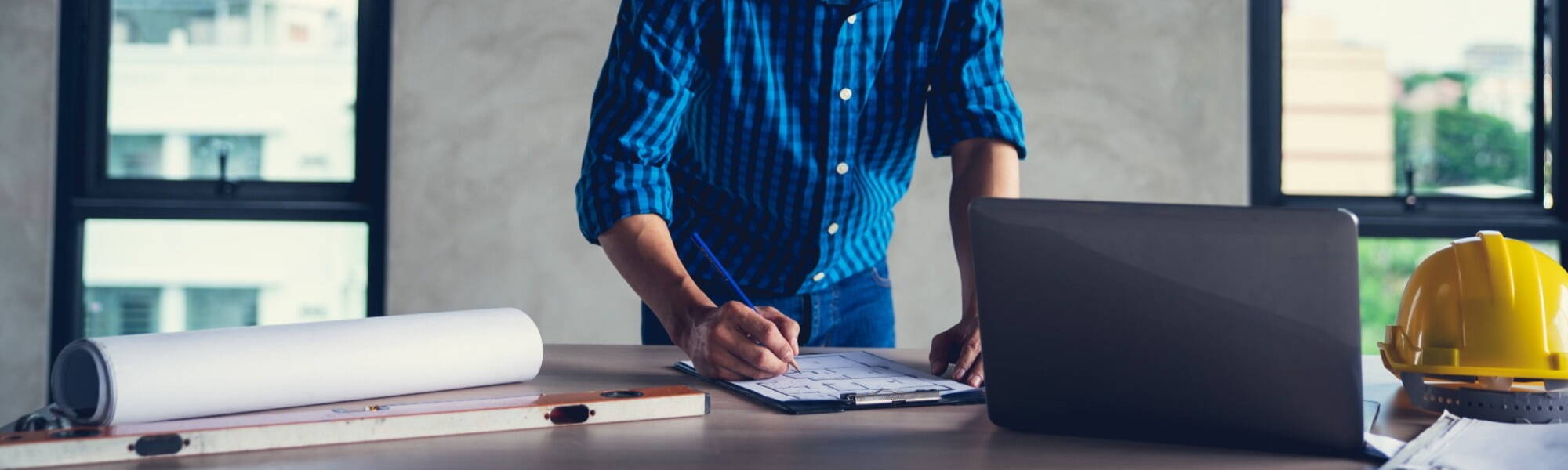 construction worker drawing plans in blue shirt