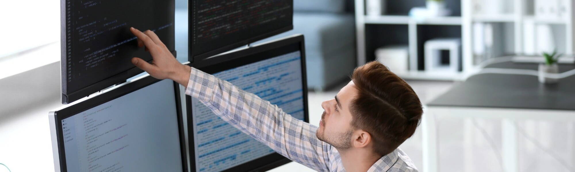 Software engineer typing source code on computer keyboard while colleagues sit down at desk for group project. App developer working in it startup company doing online cloud computing.